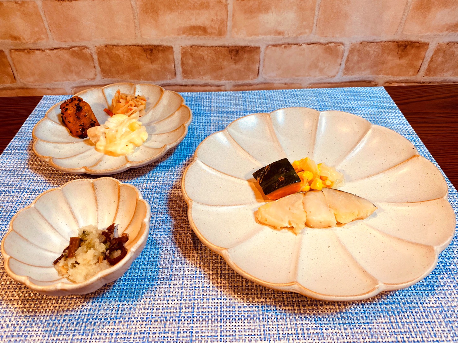 (メニューの一例)メルルーサの梅風味焼、鶏肉と玉ねぎの煮物、大学芋、山菜の和え物(わらび、ぜんまい)